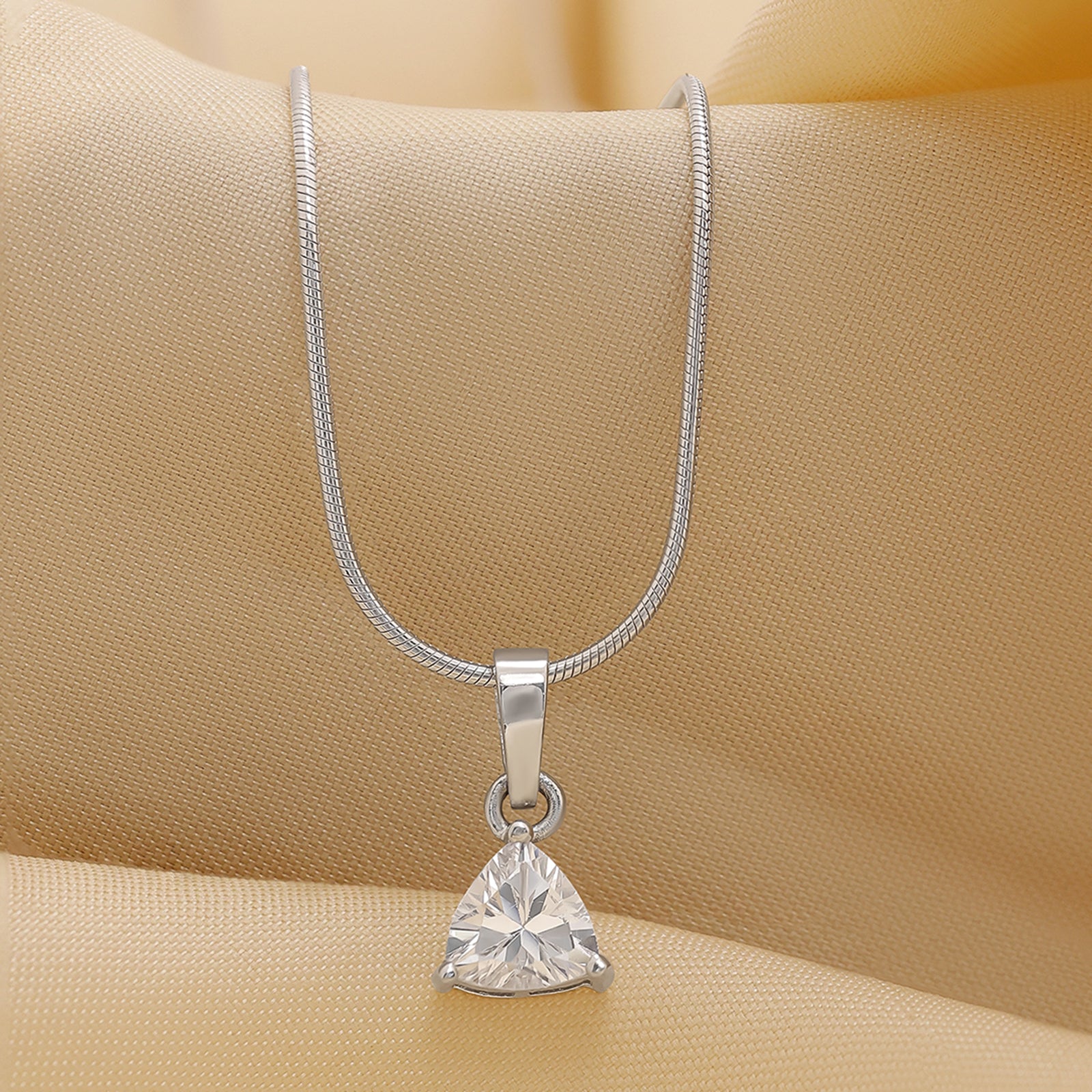 This is a silver-toned necklace with a triangular-shaped crystal or cubic zirconia pendant on a snake chain